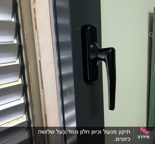 תריסים אפורים עם ידית שחורה על מסגרת חלון